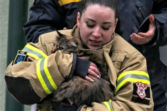 An emergency worker holds a cat rescued at the site where an apartment block was heavily damaged by a Russian missile strike, amid Russia's attack on Ukraine, in Dnipro, Ukraine on January 15, 2023. (Photo by Yevhenii Zavhorodnii/Reuters)
