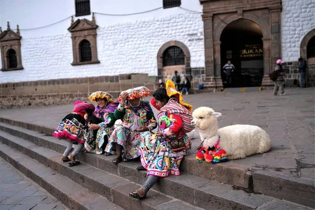 Women from the town of Paucartambo wait for tourists to take a photo with them in exchange for money, in downtown Cuzco, Peru, Wednesday, February 1, 2023. (Photo by Rodrigo Abd/AP Photo)