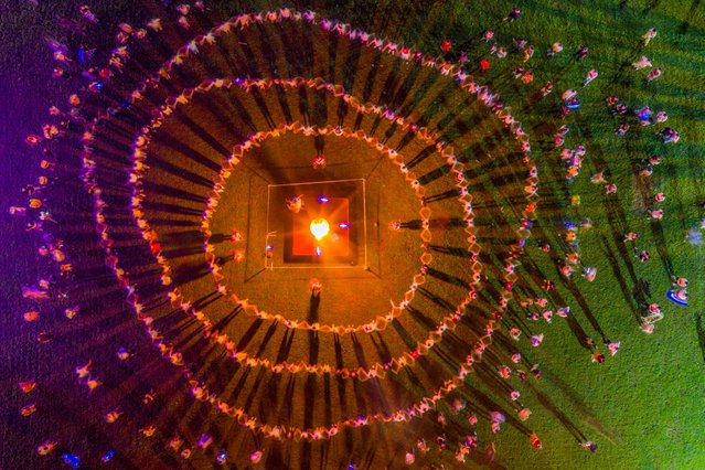 Tourists and locals dance around a bonfire in Yue Opera Town at night on July 12, 2025 in Shengzhou, Shaoxing City, Zhejiang Province of China. (Photo by Pan Weifeng/VCG via Getty Images)