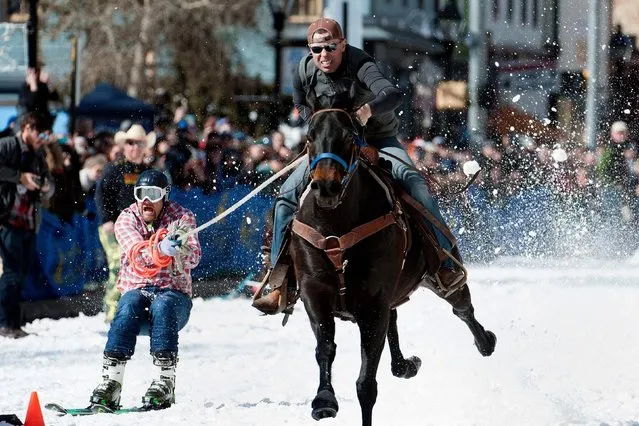 Rider Eric Mikkelson and skier Jason Dahl race to the finish line during the 70th annual Leadville Ski Joring weekend competition on March 3, 2018 in Leadville, Colorado. Ski Joring, which has its origins as a competitive sport in Scandinavia, has been adapted over the years to include jumps, slalom gates, and spearing rings for points. Leadville has been hosting skijoring competitions since 1949. (Photo by Jason Connolly/AFP Photo)