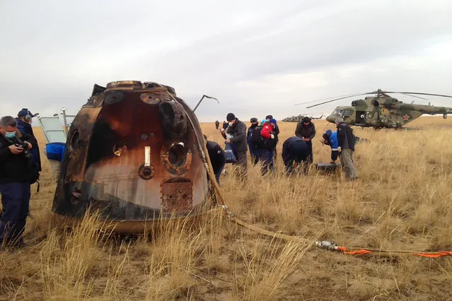 In this photo released by Roscosmos Space Agency, a Russian rescue team works near a Russian Soyuz MS-16 capsule landed near town of Dzhezkazgan, Kazakhstan, Thursday, October 22, 2020. The Soyuz MS-16 capsule carrying NASA astronaut Chris Cassidy, and Roscosmos' Anatoly Ivanishin and Ivan Vagner landed on the steppes of Kazakhstan, southeast of the town of Dzhezkazgan, on Thursday. After a brief medical checkup, the three will be taken by helicopters to Dzhezkazgan from where they will depart home. (Photo by Roscosmos Space Agency via AP Photo)