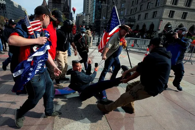 Demonstrators remove a counter-demonstrator during a rally in support of U.S. President Donald Trump sponsored by Super Happy Fun America, in Boston, Massachusetts, U.S., October 18, 2020. (Photo by Brian Snyder/Reuters)