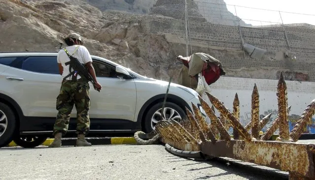 A militant loyal to Yemen's government searches a car at a checkpoint in the country's southern port city of Aden October 19, 2015. (Photo by Reuters/Stringer)