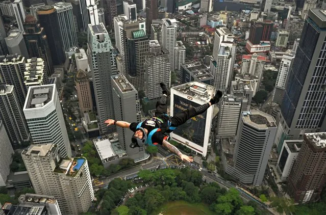 Base jumper Chris Mcdougall of Australia leaps from the 300-metre high open deck of Malaysia's landmark Kuala Lumpur Tower during the International Tower Jump in Kuala Lumpur on February 3, 2023. (Photo by Mohd Rasfan/AFP Photo)