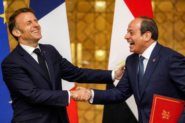 Egypt's President Abdel Fattah al-Sisi (R) and French President Emmanuel Macron react as they shake hands and exchange signed-bilateral agreements during their meeting at the Presidential Palace in Cairo on April 7, 2025. France's President started talks dominated by the Gaza war on April 6, 2025, with Egypt's President Abdel Fattah al-Sisi after arriving in Cairo. On April 7, Macron, Sisi and Jordan's King Abdullah II will hold a summit as Israel renews its offensive against Hamas in Gaza. (Photo by Ludovic Marin/Pool via AFP Photo)