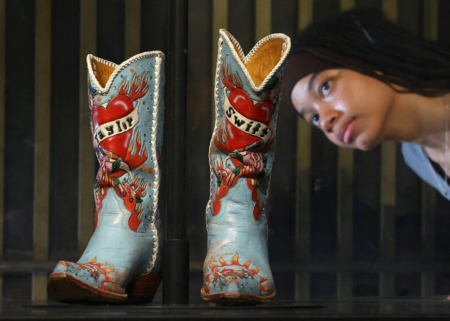 Employee Saffron poses as she views cowboy boots worn and loaned by Taylor Swift, which form part of the Taylor Swift Songbook Trail exhibition celebrating the work of the music artist at the V&A Museum in London, Britain, on July 24, 2024. (Photo by /Reuters)