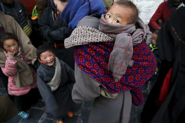 Tibetan pilgrims and their children wait to enter the Jokhang Temple in central Lhasa, Tibet Autonomous Region, China early November 20, 2015. (Photo by Damir Sagolj/Reuters)