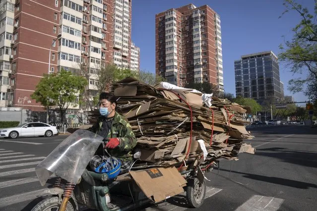 A recycler drives a cart loaded with scrap cardboard along a street in Beijing, Tuesday, April 18, 2023. China’s economy grew 4.5% in the first quarter of the year, boosted by increased consumption and retail sales, after authorities abruptly abandoned the stringent “zero-COVID” strategy. (Photo by Mark Schiefelbein/AP Photo)