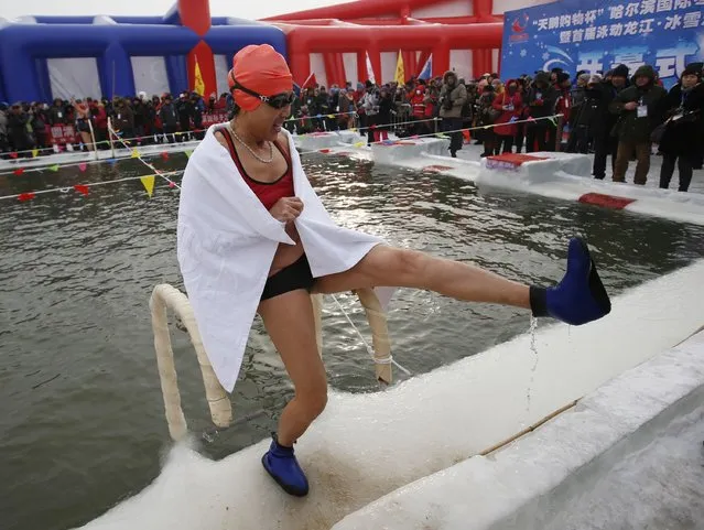 A swimmer pours water out of her boots after finishing her competition in a pool carved into thick ice covering the Songhua River during the Harbin Ice Swimming Competition in the northern city of Harbin, Heilongjiang province January 5, 2015. (Photo by Kim Kyung-Hoon/Reuters)