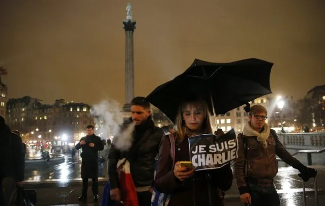 A woman holds a sign during a vigil to pay tribute to the victims of a shooting by gunmen at the offices of weekly satirical magazine Charlie Hebdo in Paris, at Trafalgar Square in London January 7, 2015. (Photo by Suzanne Plunkett/Reuters)