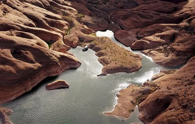 A houseboat camps on the shore in shallow water in a canyon at Lake Powell near Page, Arizona, May 26, 2015. (Photo by Rick Wilking/Reuters)
