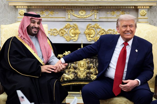 Saudi Crown Prince and Prime Minister Mohammed bin Salman holds President Donald Trump's hand during a meeting in the Oval Office on November 18, 2025. (Photo by Evelyn Hockstein/Reuters)