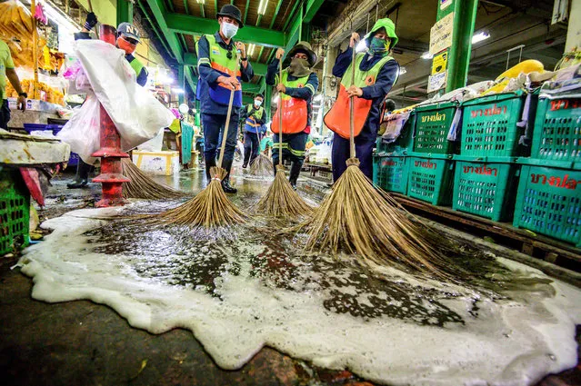 Employees of the Bangkok Metropolitan Authority clean and disinfect the Yodpiman Flower Market in Bangkok on January 6, 2021, after the government imposed further restrictions due to the recent Covid-19 coronavirus outbreak. (Photo by Mladen Antonov/AFP Photo)