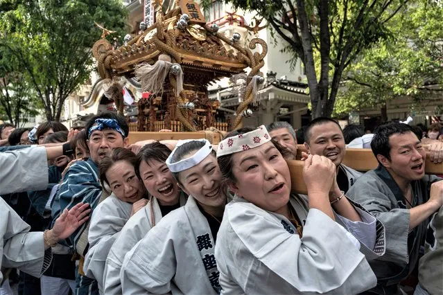 Participants carry a portable shrine or “mikoshi” through the streets during a local festival, or “matsuri”, in the Higashi-Ginza area of Tokyo on May 3, 2023. Japan on May 3 marked Constitution Day, one of four public holidays at the end of April and beginning of May which make up “Golden Week”, one of the country's big three holiday periods. (Photo by Richard A. Brooks/AFP Photo)