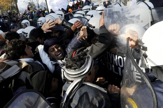 Stranded migrants scuffle with Greek police officers as they try to cross the Greek-Macedonian border, near the village of Idomeni, Greece  December 2, 2015. (Photo by Alexandros Avramidis/Reuters)