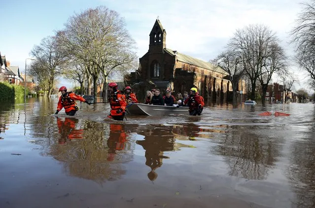 Rescue workers pull a boat full of rescued residents along a flooded residential street in Carlisle, Britain December 6, 2015. (Photo by Phil Noble/Reuters)