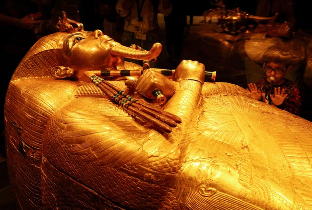 A child looks at the golden coffin of ancient Egyptian Pharaoh Tutankhamun during the first day for visitors after the official opening of the Grand Egyptian Museum (GEM), near the Giza pyramid complex, in Giza, Egypt. on November 4, 2025. (Photo by Mohamed Abd El Ghany/Reuters)