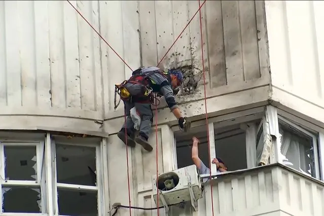 In this image taken from video, investigators inspect the building after a Ukrainian drone damaged an apartment building in Moscow, Russia, Tuesday, May 30, 2023. In Moscow, residents reported hearing explosions and Mayor Sergei Sobyanin later confirmed there had been a drone attack that he said caused “insignificant” damage. (Photo by AP Photo/Stringer)