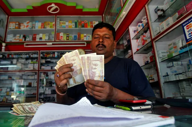 A shopkeeper counts 500 Indian rupee banknotes at a cash counter inside a medicine shop in Agartala, India, November 9, 2016. (Photo by Jayanta Dey/Reuters)