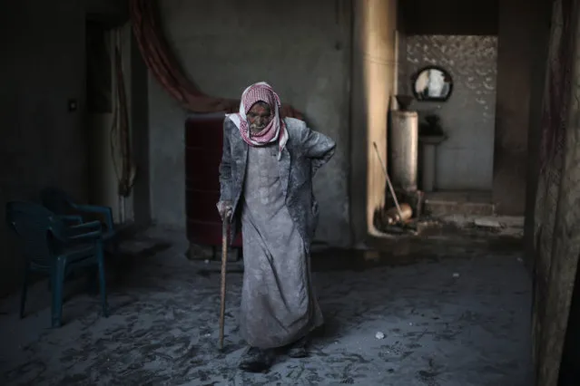 Syrian Abu Mohammed, covered with dust from explosions, walks in his home following reported air strikes by regime forces on the town of al-Nashabiyah in the eastern Ghouta region, a rebel stronghold east of the capital Damascus, on December 14, 2015. United Nations aid chief Stephen O'Brien said that the “indiscriminate attacks” against civilians in Damascus and the surrounding region were “unacceptable” at the end of a visit to Syria. (Photo by Amer Almohibany/AFP Photo)