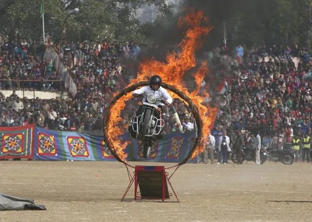 An Indian policeman performs a stunt on his motorcycle during the Republic Day parade in Jammu January 26, 2015. (Photo by Mukesh Gupta/Reuters)