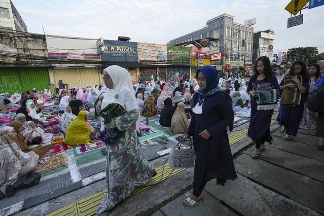 Muslims arrive for a morning prayer marking the Eid al-Adha holiday on a street in Jakarta, Indonesia, Thursday, June 29, 2023. Muslims around the world will celebrate Eid al-Adha, or the Feast of the Sacrifice, slaughtering sheep, goats, cows and camels to commemorate Prophet Abraham's readiness to sacrifice his son Ismail on God's command. (Photo by Tatan Syuflana/AP Photo)