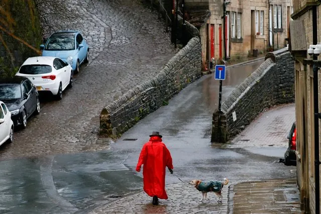 A woman walks her dog as the city prepares for potential flooding due to the arrival of Storm Christoph, in Hebden Bridge, Britain, January 19, 2021. (Photo by Phil Noble/Reuters)