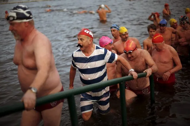 Swimmers climb out after taking part in the annual Christmas Day Peter Pan Cup handicap race in the Serpentine River, in Hyde Park, London, December 25, 2015. (Photo by Andrew Winning/Reuters)