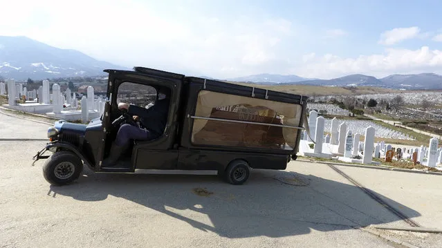 A cemetery worker transports the coffin that contains the remains of person believed to have died from the new coronavirus, to a burial site at Sarajevo cemetery Vlakovo, Bosnia, Friday, March 19, 2021. Hospitals and the morgue in Sarajevo are overwhelmed as dozens of people died in the past days since the sharp rise in virus  infections has been recorded throughout the country. (Photo by AP Photo/Stringer)