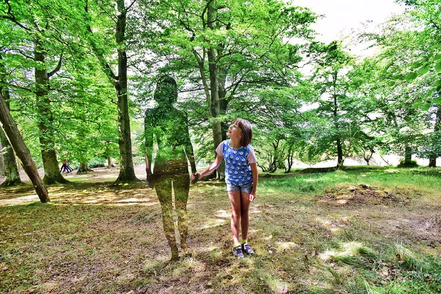 A new temporary art installation of mirrored figures located in County Durham woodland closely resembles the invisible cloak used by the alien in the 1980s film Predator. The polished steel sculptural installation named Natural Creation, by artist Rob Mulholland, is situated in woodland at Low Force in Teesdale, County Durham, UK and is designed to reflect the local volcanic geology. Here, eight-year-old Isla takes a closer look at one of the reflective figurines on August 1, 2018. (Photo by Paul Kingston/North News & Pictures)