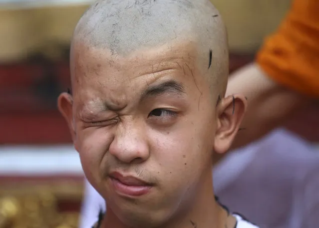 Soccer team member Pornchai Kamluang, his coach, and his teammates who were rescued last week from a flooded cave have their heads shaved in a traditional Buddhist ceremony in Mae Sai district, Chiang Rai province, northern Thailand, Tuesday, July 24, 2018. The young soccer teammates and their coach who have rescued from the cave in northern Thailand took part in a Buddhist ceremony Tuesday as they prepared to be ordained to become Buddhist novices and monks. (Photo by Sakchai Lalit/AP Photo)