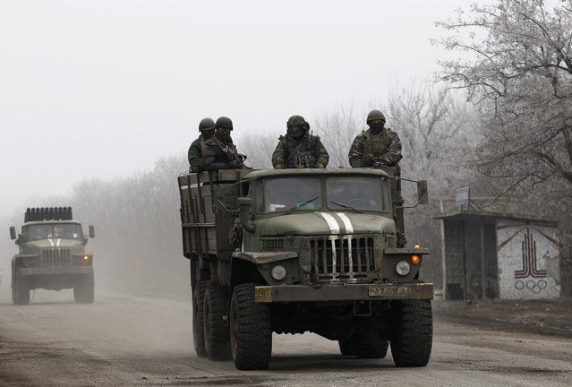 Ukrainian government soldiers ride on a vehicle on the road between the towns of Dabeltseve and Artemivsk, Ukraine, Saturday, February 14, 2015. (Photo by Petr David Josek/AP Photo)