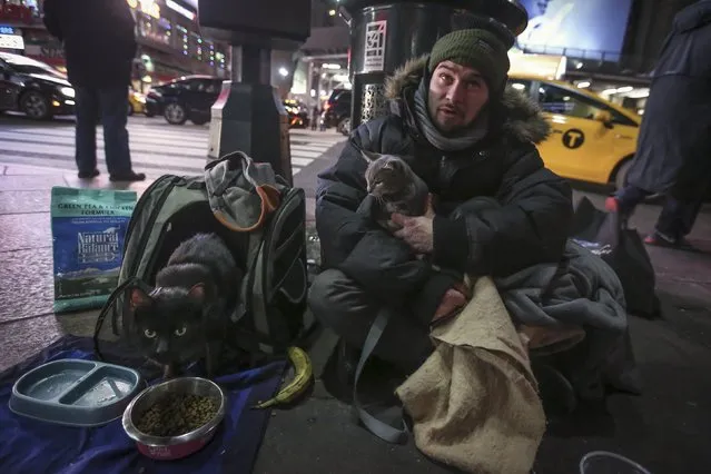 Keith Rosario sits with his cats Storm and Molly (L) as he panhandles on the street outside Pennsylvania Station in the Manhattan borough of New York, January 5, 2016. (Photo by Carlo Allegri/Reuters)