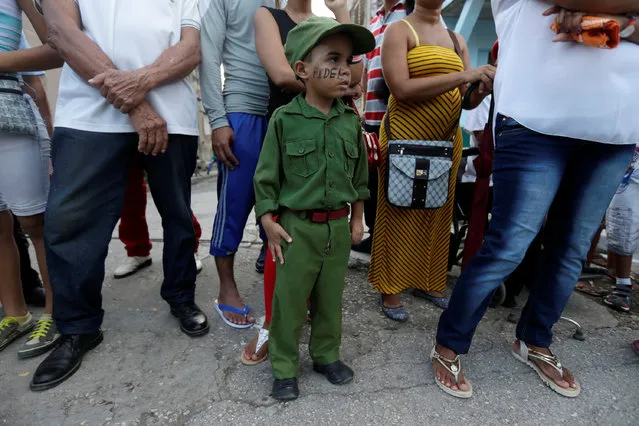 People wait along a street for the ashes of Cuba's former President Fidel Castro to pass during a journey to the eastern city of Santiago de Cuba, in Bayamo, Cuba, December 2, 2016. (Photo by Edgard Garrido/Reuters)