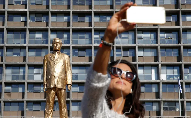 A woman takes a selfie with a statue of Israel's Prime Minister Benjamin Netanyahu, created by Israeli artist Itay Zalait as a political protest against Netanyahu, which was placed without official permission outside Tel Aviv's city hall, Israel December 6, 2016. Israeli artist  Itay Zalait said he placed the 4.5 meter (15 foot) statue early Tuesday. Zalait says his goal is to test freedom of expression with a reference to the biblical golden calf, and a dig at some Israelis idolatry of longtime leader Benjamin Netanyahu. City Hall said it was placed without a permit and has ordered it removed. (Photo by Baz Ratner/Reuters)