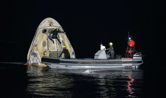 This handout image courtesy of NASA and made available on May 2, 2021, shows the support teams working around the SpaceX Crew Dragon Resilience spacecraft shortly after it landed with NASA astronauts Mike Hopkins, Shannon Walker, and Victor Glover, and Japan Aerospace Exploration Agency (JAXA) astronaut Soichi Noguchi aboard in the Gulf of Mexico off the coast of Panama City, Florida on May 2, 2021. NASA’s SpaceX Crew-1 mission was the first crew rotation flight of the SpaceX Crew Dragon spacecraft and Falcon 9 rocket with astronauts to the International Space Station as part of the agency’s Commercial Crew Program. (Photo by Bill Ingalls/NASA via AFP Photo)