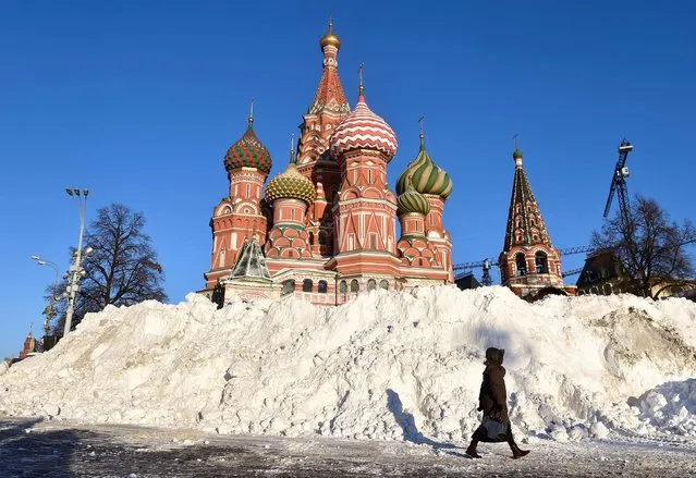 A woman walks past a snow heap at Red Square, with St. Basil's Cathedral seen in the background, as temperatures dropped to -13 degrees Celsius in Moscow on December 7, 2016. (Photo by Natalia Kolesnikova/AFP Photo)