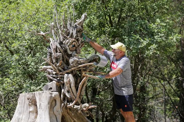 Russian sculptor Mikhail Tchernega works on a sculpture made from tree branches at Goynuk Canyon in Kemer district of Antalya, Turkiye on August 24, 2023. Sculptor Tchernega creates sculptures with tree branches he collects from the stream to convey the importance of the environment and wildlife. (Photo by Orhan Cicek/Anadolu Agency via Getty Images)
