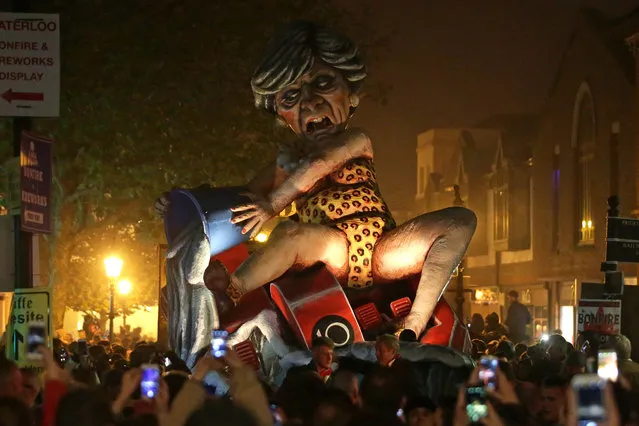 An effigy of Britain' s Prime Minister Theresa May paraded through the streets of Lewes in East Sussex, southern England, on November 5, 2018, during the traditional Bonfire Night celebrations. Thousands of people attend the annual parade through the narrow streets until the evening comes to an end with the burning of an effigy or “guy”, usually representing Guy Fawkes, who died in 1605 after an unsuccessful attempt to blow up The Houses of Parliament. (Photo by Daniel Leal-Olivas/AFP Photo)
