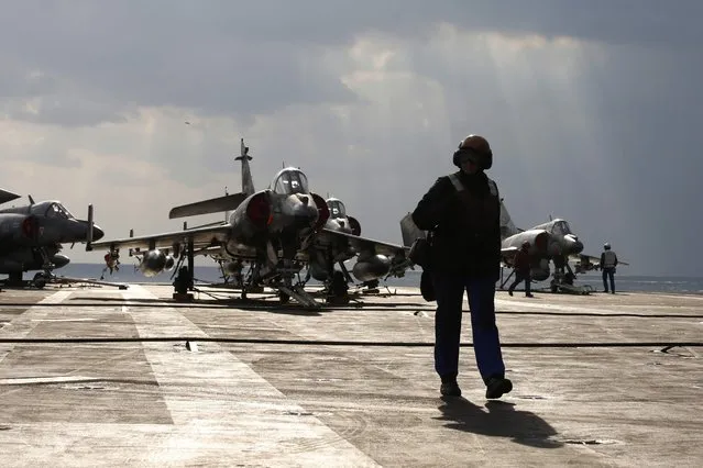 A crew member walks on the flight deck past Super Etendards fighter jets aboard France's Charles de Gaulle aircraft carrier on mission in the Gulf, January 29, 2016. (Photo by Philippe Wojazer/Reuters)