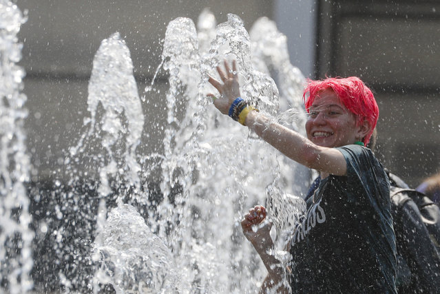 A girl plays in a water-jets fountain in Moscow, Russia, 23 June 2021. The temperature exceeded 36 degrees Celsius in Moscow. The weather in Moscow broke the temperature record high of the day, held since 1948, when meteorologists recorded +33.6. (Photo by Sergei Ilnitsky/EPA/EFE)