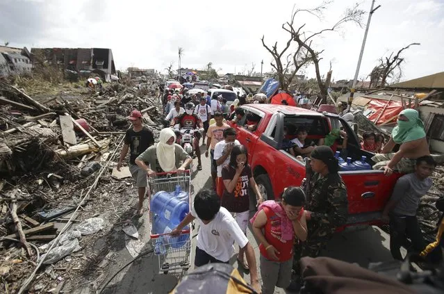 Survivors fill the streets to the downtown area as they race for supplies at typhoon ravaged Tacloban city, Leyte province central Philippines on Monday, November 11, 2013. (Photo by Aaron Favila/AP Photo)