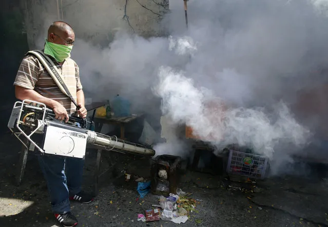 A municipal worker carries out fumigation as a preventive measure on the spreading of mosquito-borne diseases in a slum area in the Paranaque city of Metro Manila, Philippines February 2, 2016. (Photo by Romeo Ranoco/Reuters)