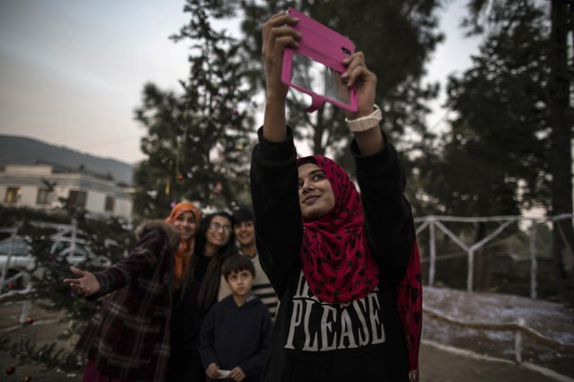 Muslims take a selfie near a Christmas tree ahead of Christmas in a Christian slum in Islamabad, in this December 24, 2014 file photo. (Photo by Zohra Bensemra/Reuters)
