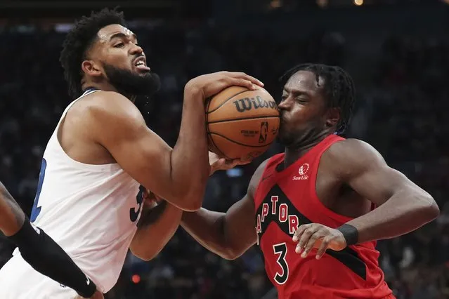 Minnesota Timberwolves' Karl-Anthony Towns (32) hits Toronto Raptors' O.G. Anunoby (3) on the face with the ball as he drives to the basket during the second half of an NBA basketball game Wednesday, October 25, 2023, in Toronto. (Photo by Nathan Denette/The Canadian Press via AP Photo)