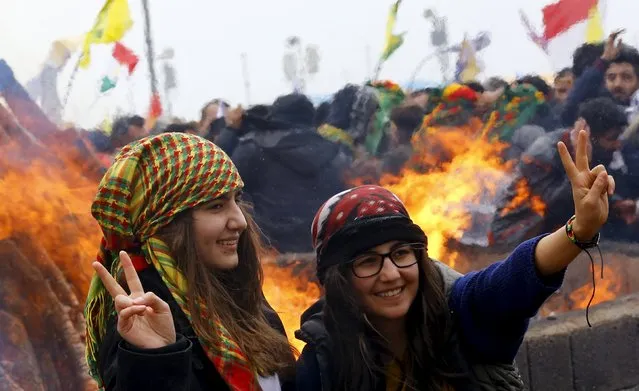 Kurdish girls gesture in front of a bonfire during a gathering celebrating Newroz, which marks the arrival of spring and the new year, in Diyarbakir March 21, 2015. Jailed Kurdish rebel leader Abdullah Ocalan called on Saturday for his militant group to hold a congress on ending a three-decade insurgency against the Turkish state but stopped short of declaring an immediate halt to its armed struggle. (Photo by Umit Bektas/Reuters)