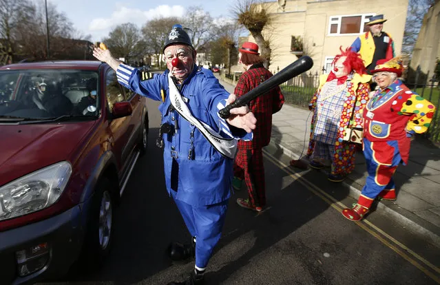 The clown “PC Konk” pretends to direct traffic outside the All Saints Church before the Grimaldi clown service in Dalston, north London, February 7, 2016. (Photo by Peter Nicholls/Reuters)