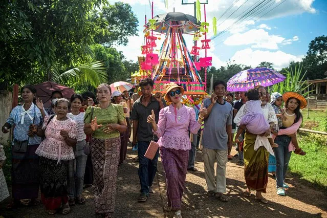 This photo taken on October 14, 2023 shows women, some in traditional outfit, dancing as they take part in a parade during the thai-khmer Sandonta festival, in Kantharalak district, Thailand's northeastern Si Sa Ket province. Sandonta or Sart-Khmer is a tradition to pay homage to the spirits of ancestors in the south of Isan near the cambodian border. (Photo by Amaury Paul/AFP Photo)