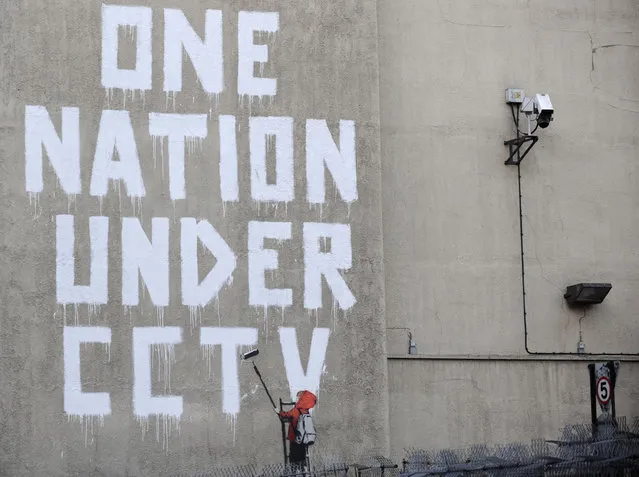 Street graffiti by Banksy on a wall next to a CCTV camera in central London in 2008. (Photo by Toby Melville/Reuters)