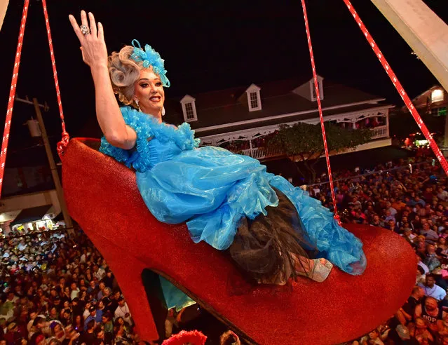 “Sushi”, portrayed by female impersonator Gary Marion, hangs in a giant replica of a woman's red high heel over Duval Street during the “Red Shoe Drop” New Year event at the Bourbon St. Pub in Key West, Florida in this late December 31, 2016 handout photo. (Photo by Rob O'Neal/Reuters/Florida Keys News Bureau)
